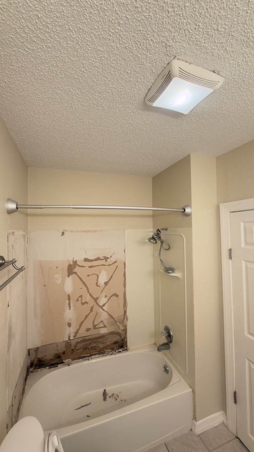 Before: damaged bath walls during renovation